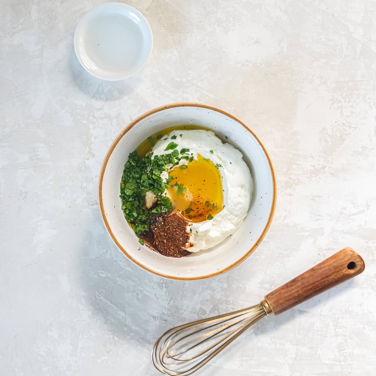 Greek yogurt, cilantro, lime juice, olive oil, taco seasoning, honey, and black pepper added to a bowl before mixing.