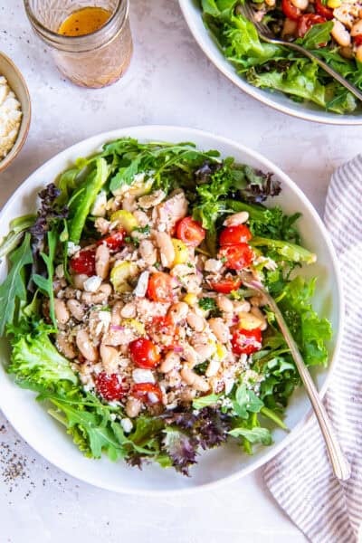 Tuna and White Bean Salad served over mixed greens with cannellini beans, albacore tuna, cherry tomatoes, celery, red onion, capers, feta cheese, and red wine vinaigrette.