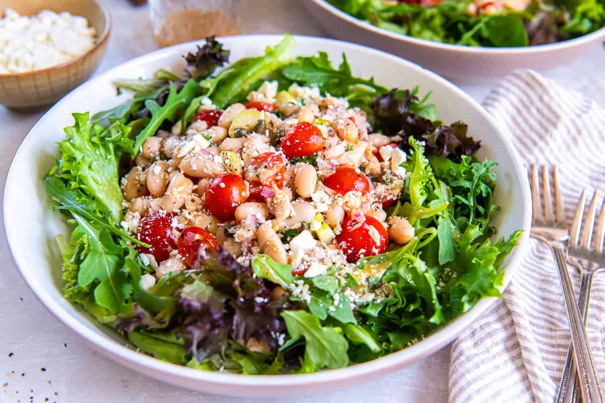 Tuna White Bean Salad with cannellini beans, cherry tomatoes, capers, red onion, feta cheese, and mixed greens, dressed with a homemade red wine vinaigrette.
