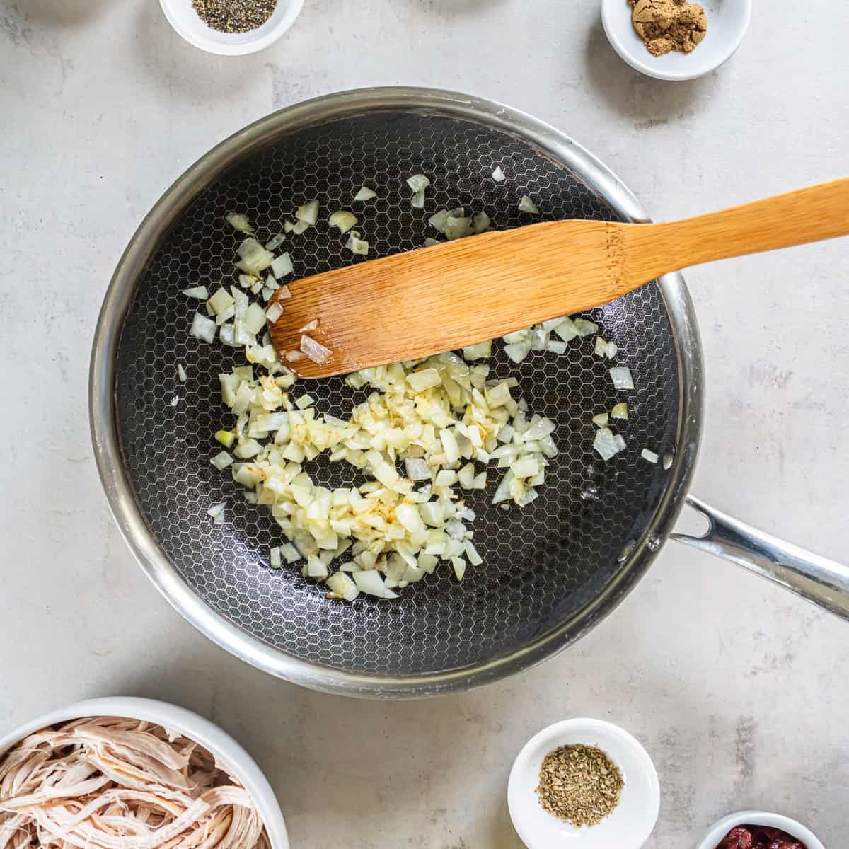 Diced onion sautéing in a skillet for Rotisserie Chicken Tacos.