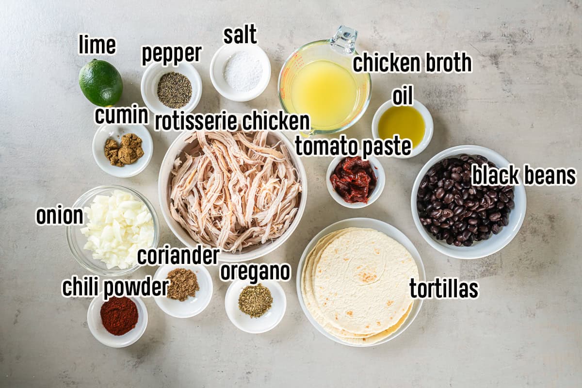 Ingredients for Rotisserie Chicken Tacos including shredded chicken, tortillas, black beans, onion, lime, tomato paste, chicken broth, oil, and seasonings.