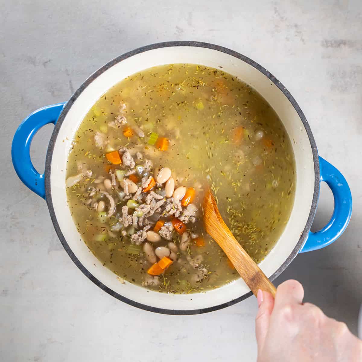 Chicken broth and cannellini beans added to the ground turkey and vegetable mixture.