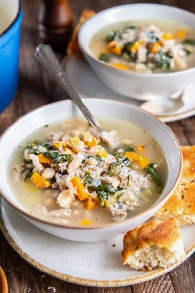 Bowl of Turkey White Bean Soup with ground turkey, cannellini beans, spinach, carrots, and Parmesan, served with crusty bread.